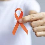 woman holding orange ribbon for MS awareness and hope for multiple sclerosis treatment