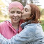 cancer patient with friend hugging her to manage side effects of chemo
